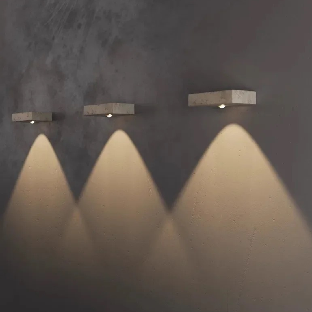 Close-up of Maelle wall lamp's natural travertine stone texture