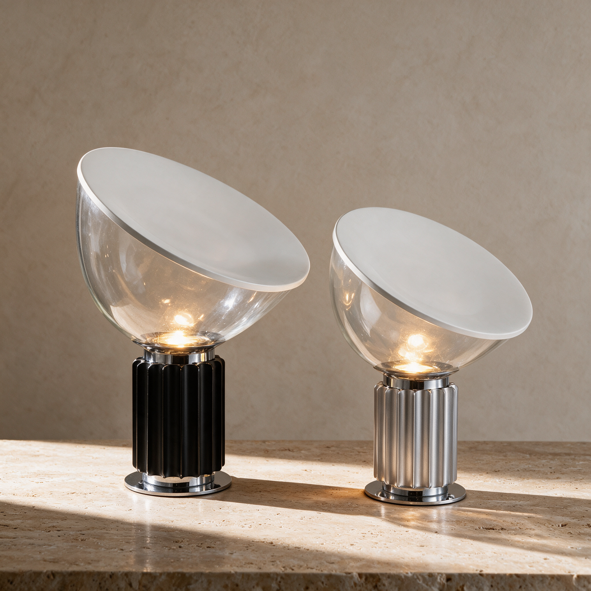 Luca Table Lamp in both sizes, black and silver, on a travertine surface