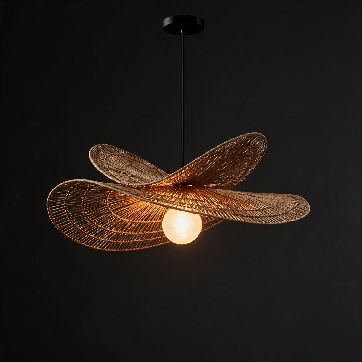 Isla Chandelier switched on, warm light glowing through the open rattan weave