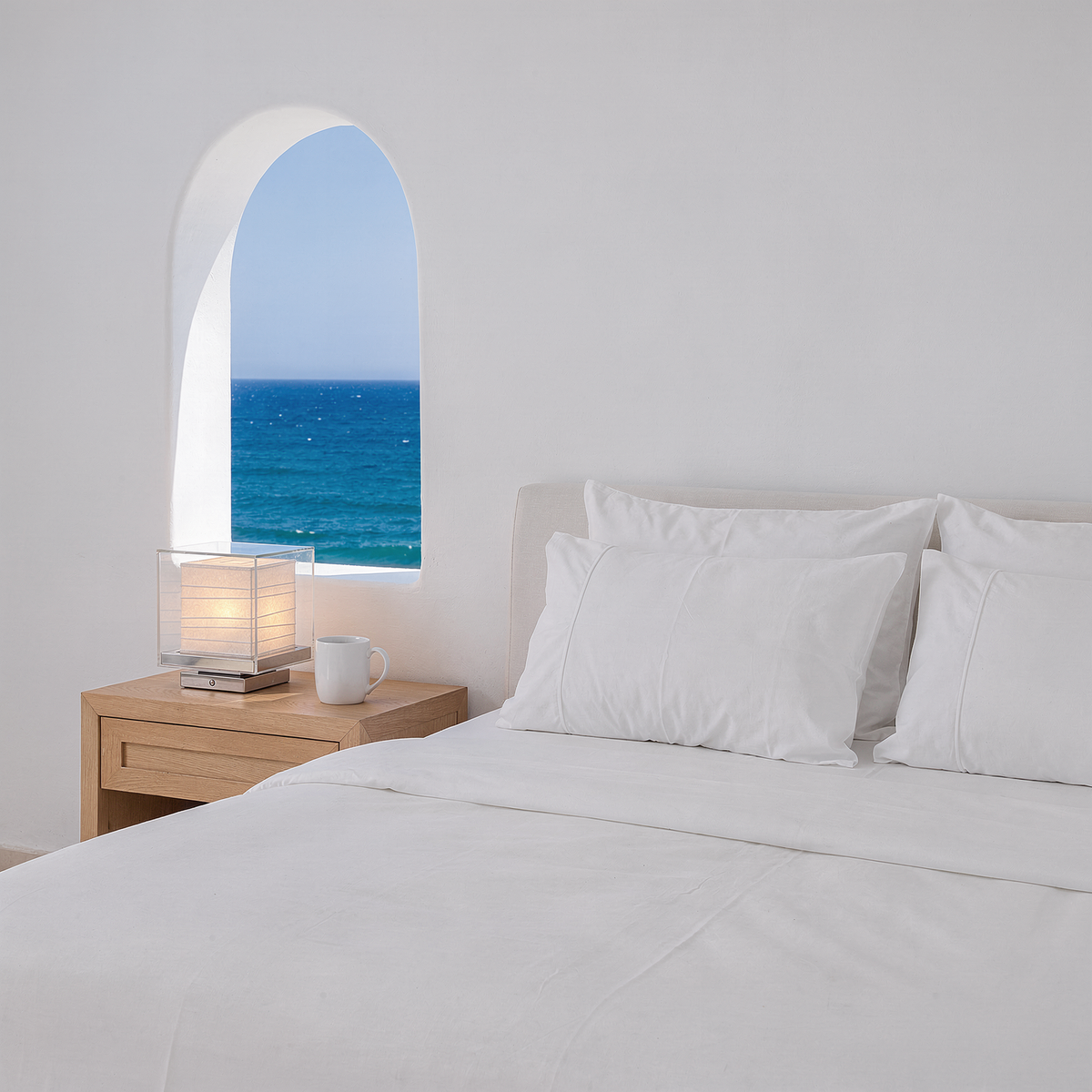 Kumo Table Lamp on an oak bedside table in a bright Mediterranean bedroom