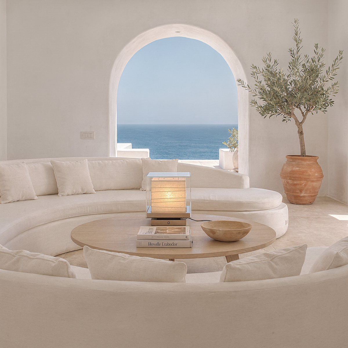 Kumo Table Lamp on a round wooden coffee table in a whitewashed island living room