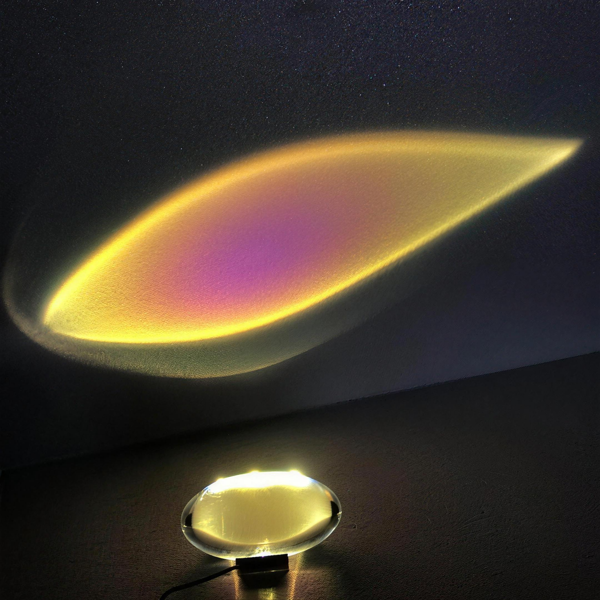 Sunlight lamp glowing gold with a magenta centre on a dark wall